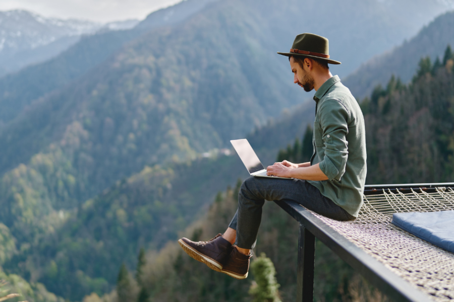 man working on laptop remotely with mountain view